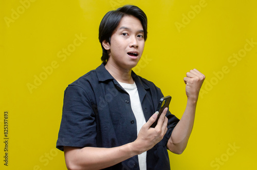 young asian man shocked covering his face after receiving unwanted news from his phone. asian man shocked watching his phone.