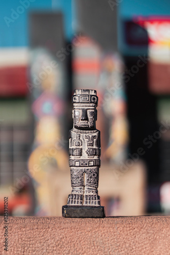 Miniature of monolith from the Tiahuanaco culture. Vertically. Background with colorful depth of field photo