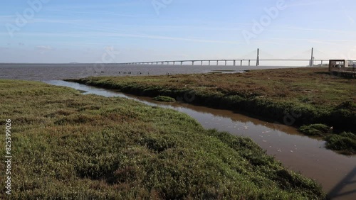 Landscape of the Tagus River in Lisbon, Portugal, with a bridge in the background.