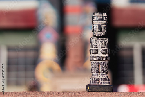 Miniature of monolith from the Tiahuanaco culture. Isolated with space for text. With colorful depth of field background photo