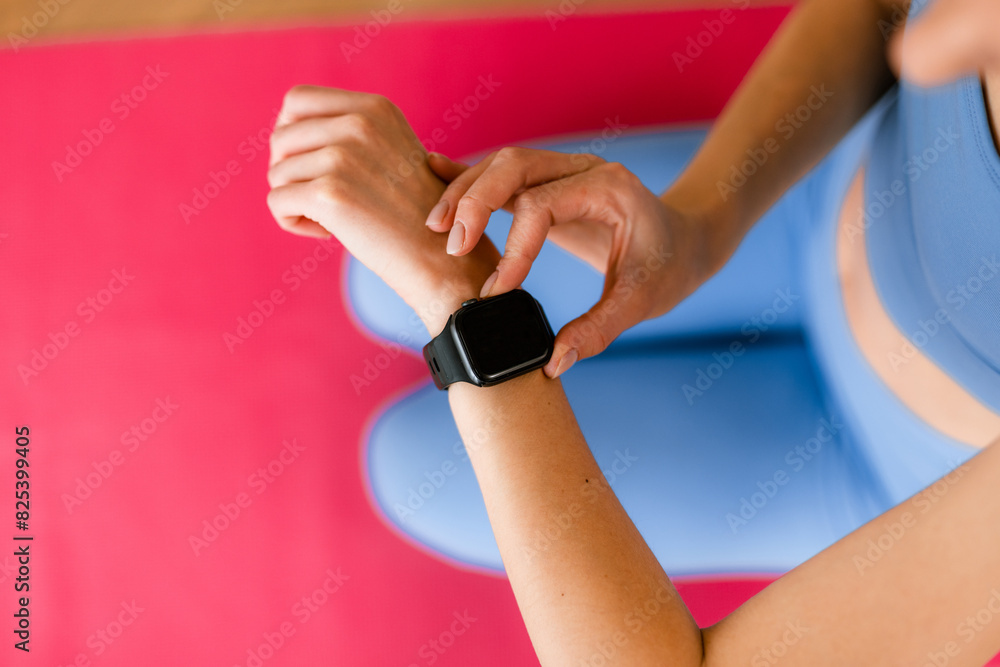 © DZ FILM/Stocksy - A woman uses her watch doing sports