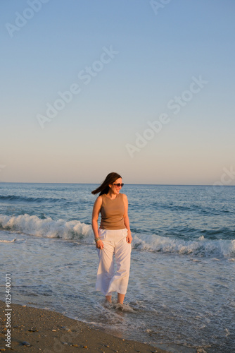 Happy traveller woman enjoys her Mediterranean Sea beach vacation.