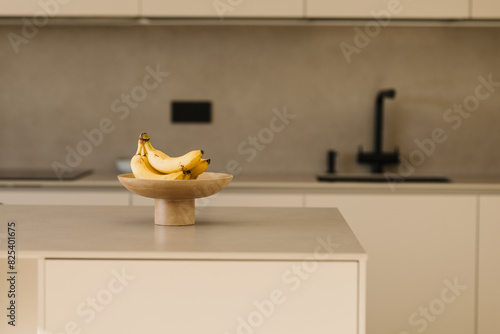 Basket with fresh Bananas on table in kitchen photo