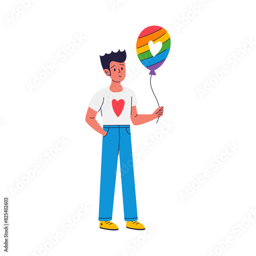 A young man is holding a rainbow-colored balloon