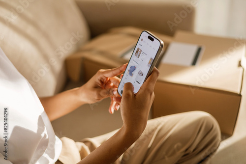 Woman online shopping with phone at home