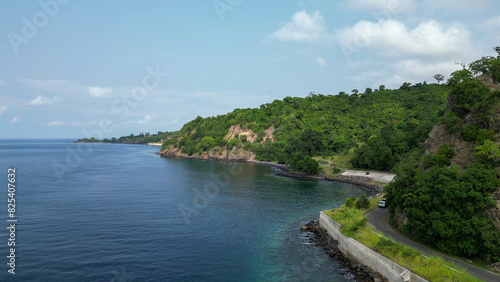 Car drives along the north coastal road between cliffs and the sea in Sao Tome and Principe  Africa