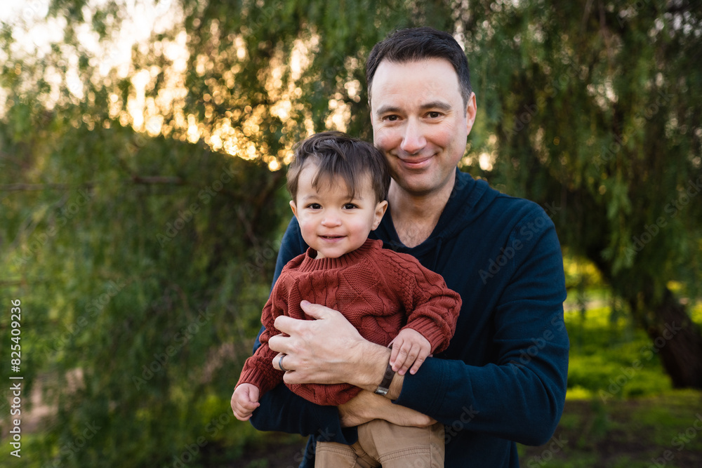 Father and Son Laugh and Smile Together Outside at Sunset Father and Son Laugh and Smile Together Outside at Sunset