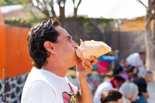 Man playing the conch in ceremony photo