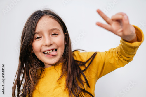 Joyful tween Girl Gesturing Peace Sign