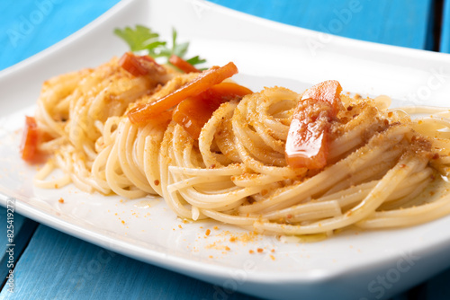 Piatto di deliziosi spaghetti conditi con bottarga di muggine, pasta italiana, cibo mediterraneo  photo