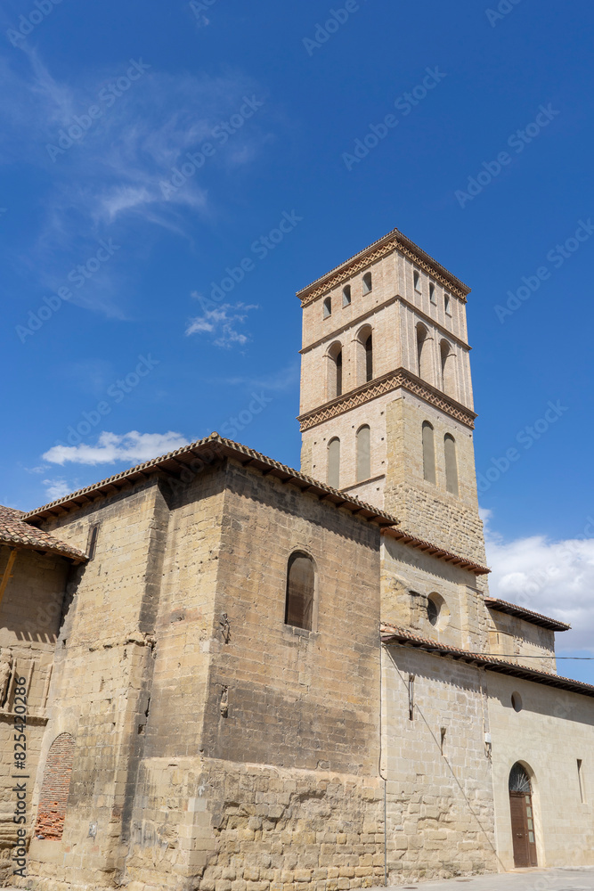 The building has many arched windows and a stone facade. Sunny day at the church of Bartolome. Spain