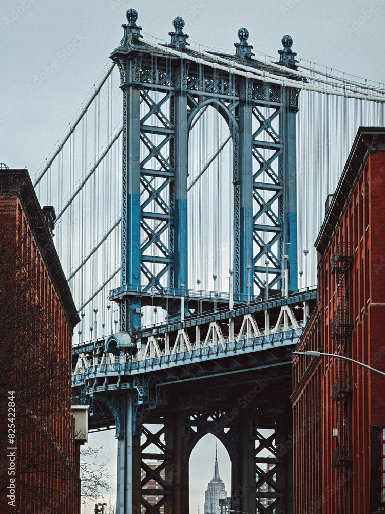 Fototapeta premium a tall bridge over a street next to a building and a traffic light