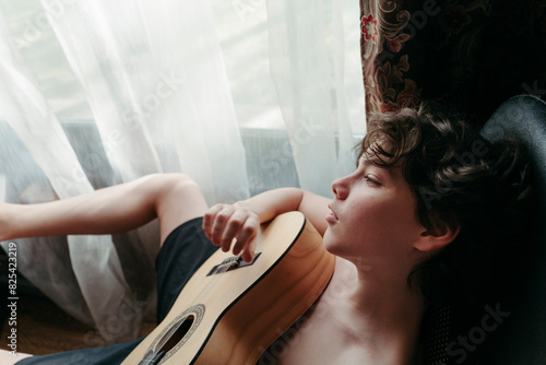 Young Musician Resting With Guitar photo