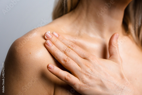 A woman applies cream to her body