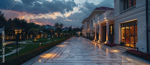 marble tile playground in the night backyard of mansion with flowerbeds and lawn with ground lamp and lighting in the warm light at dusk in the evening.