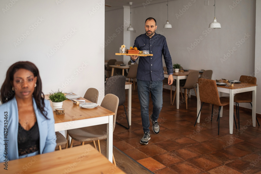black woman served by a waiter in a restaurant black woman served by a waiter in a restaurant