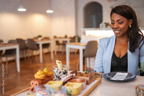 black woman eating in a restaurant photo
