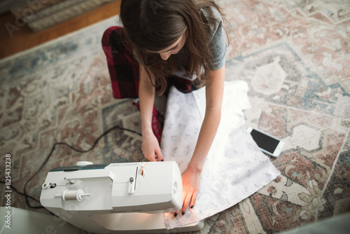 Young girl sews with sewing machine photo