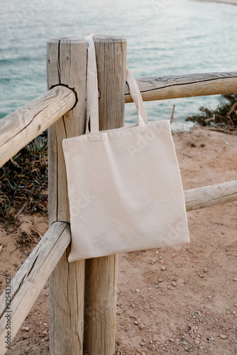 Close-up of a tote bag without patterns hanging from a wooden post photo