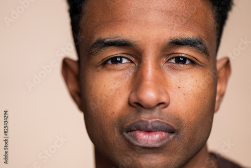 Close-up portrait of a young man with neutral expression photo