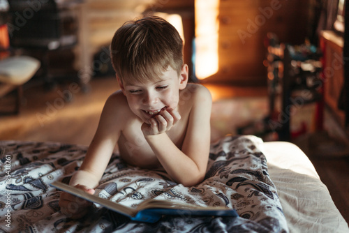 Smiling Boy Reading in Cozy Bedroom  photo