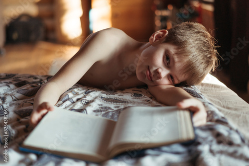 Boy Reading Book in Cozy Bedroom Light photo
