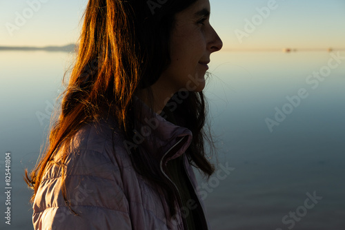 backlit profile of woman with long hair at sunset photo