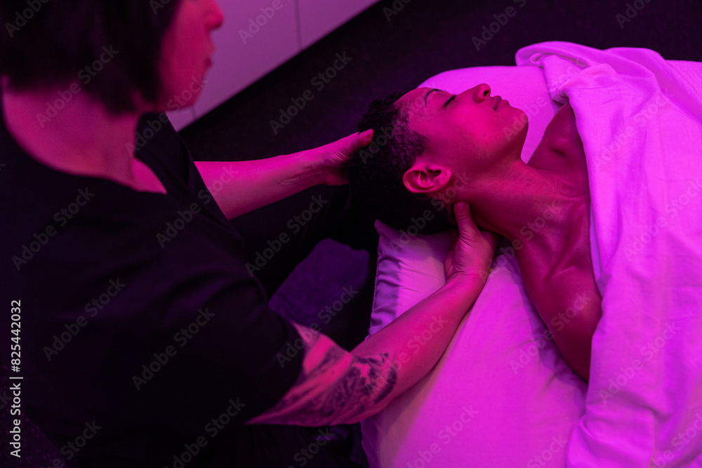 Massage therapist adjusting client's neck Massage therapist adjusting client's neck