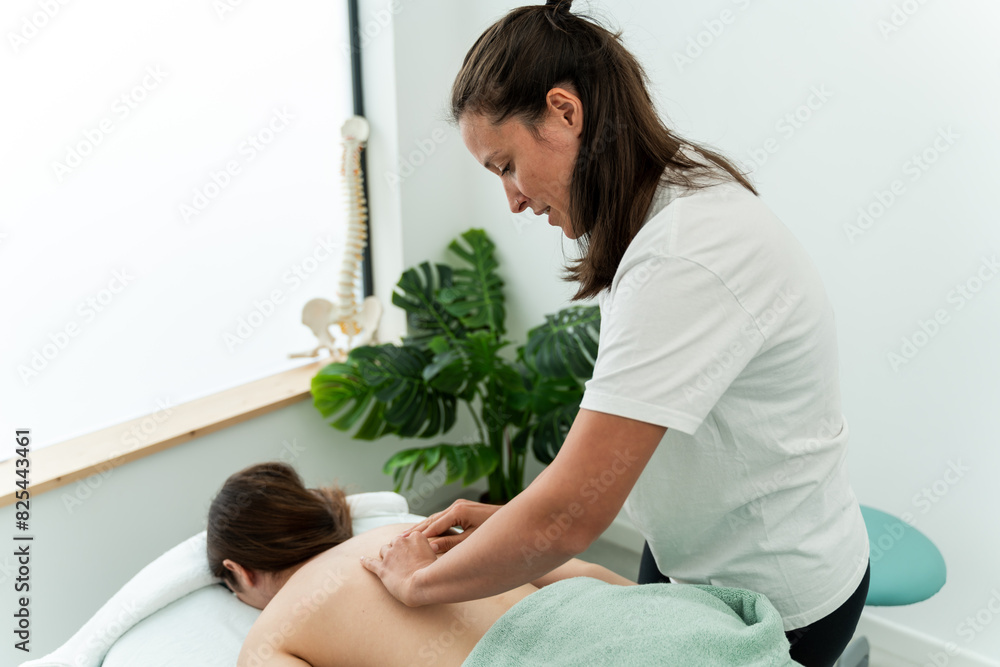 Physiotherapist giving back massage to patient Physiotherapist giving back massage to patient