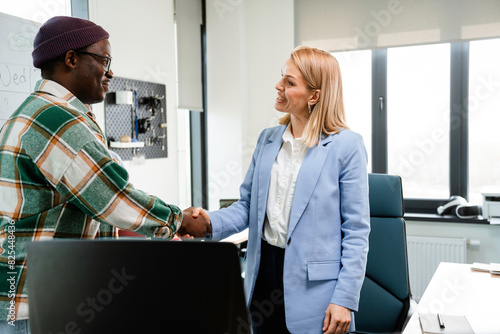 A man and a woman shake hands in the office photo