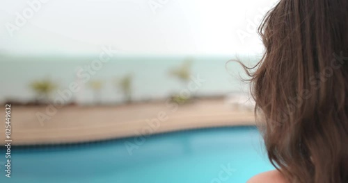 A woman stands in front of a swimming pool at a resort on Koh Phangan Island, Thailand. photo