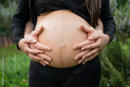 Pregnant couple holding round belly photo