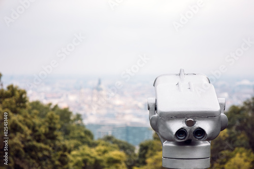 Stationary binoscope on viewing platform in Gellert Hill. Travel, tourism, outdoor lifestyle holiday vacation. View of Budapest, Hungary. Public binoculars telescope on observation deck for tourist. photo