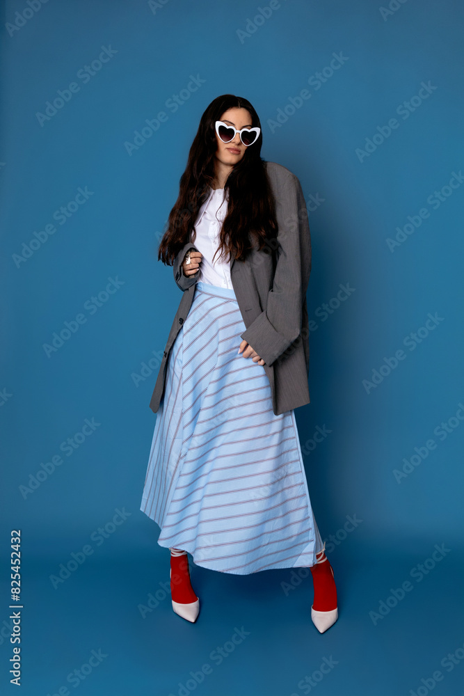Self assured model wearing stylish outfit standing in studio Self assured model wearing stylish outfit standing in studio