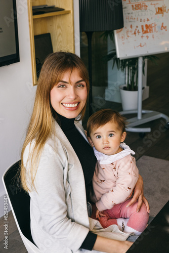 Happy businesswoman holding her son at the office photo