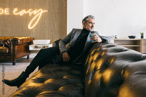 Mature stylish man relaxing on a luxury leather sofa