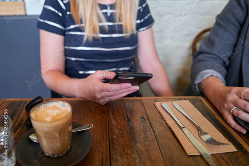 Woman holding phone sitting at cafe photo