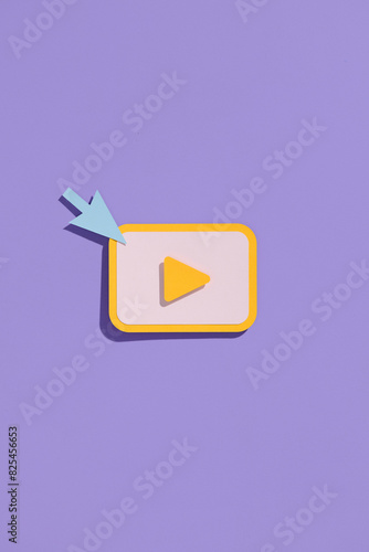 Mouse click with play button on purple background. photo