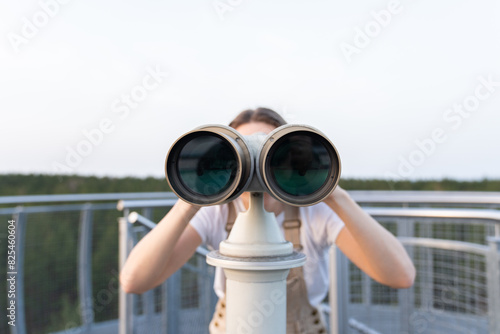 Woman Using Binoculars At Viewpoint photo