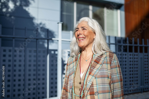 portrait of mature white-haired woman smiling on the street photo