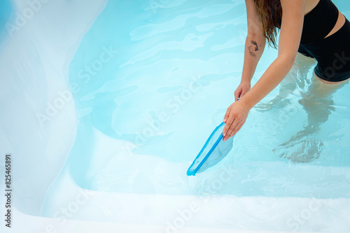Woman cleaning a pool photo