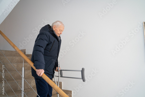 Man Going Down The Stairs With Crutches photo