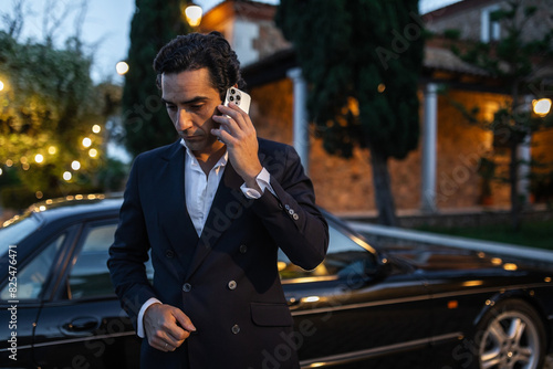 elegant young man in suit jacket using mobile phone photo