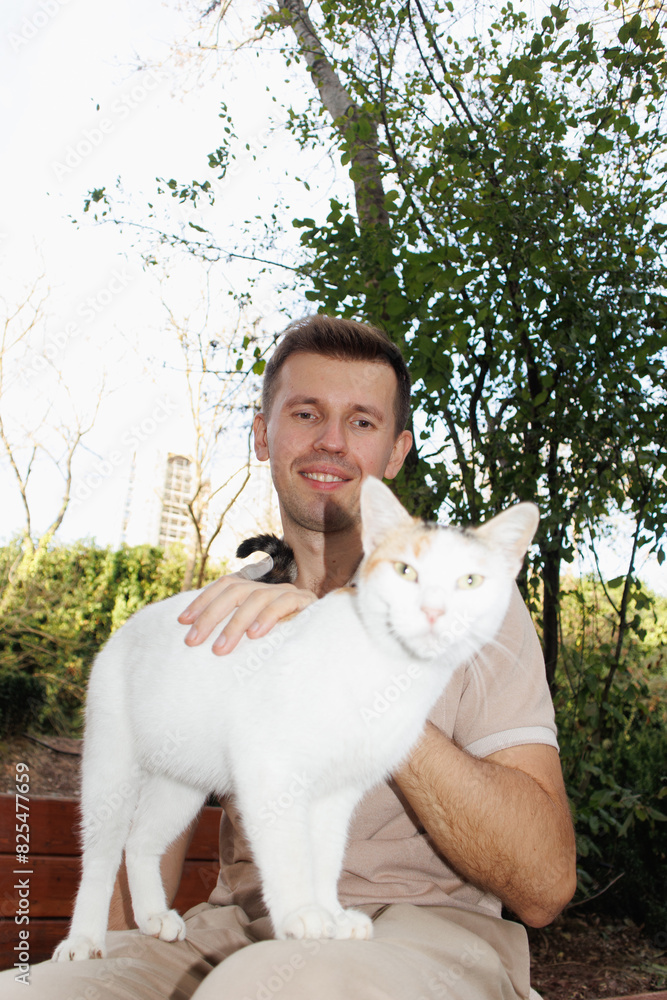 young man petting a cat young man petting a cat
