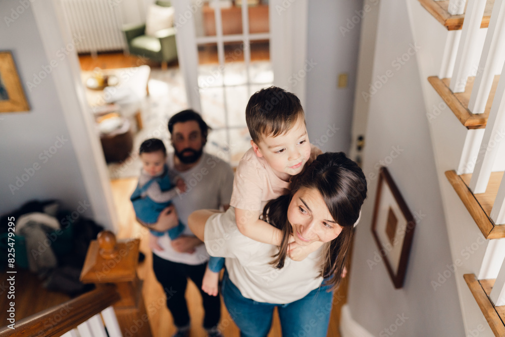 mother walking upstairs with boy on her back mother walking upstairs with boy on her back