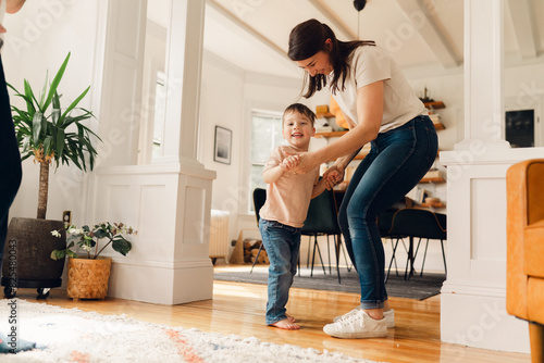 mother and little boy dancing in living room  photo