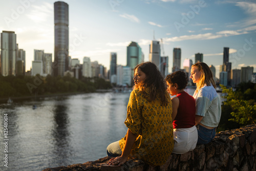 Women watching sunset over the river and the skyline photo
