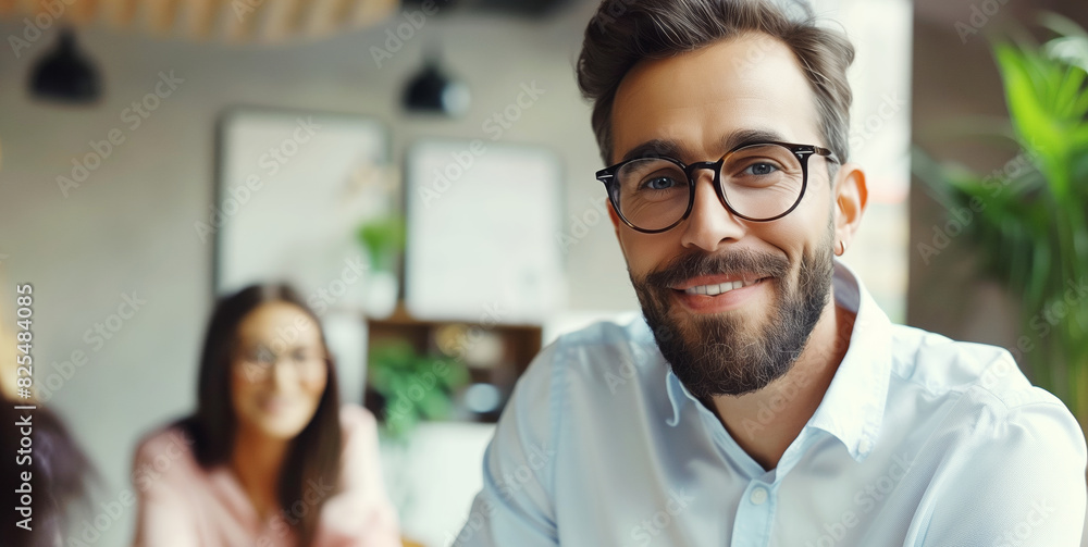 Portrait of happy smiling modern business man in glasses in office working at the laptop Portrait of happy smiling modern business man in glasses in office working at the laptop