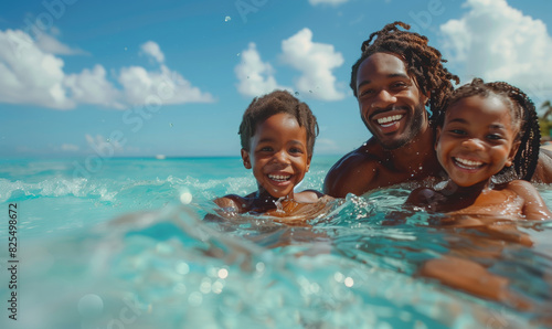 Fototapeta Naklejka Na Ścianę i Meble -  African happy father swimming with his children in the blue sea on the beach