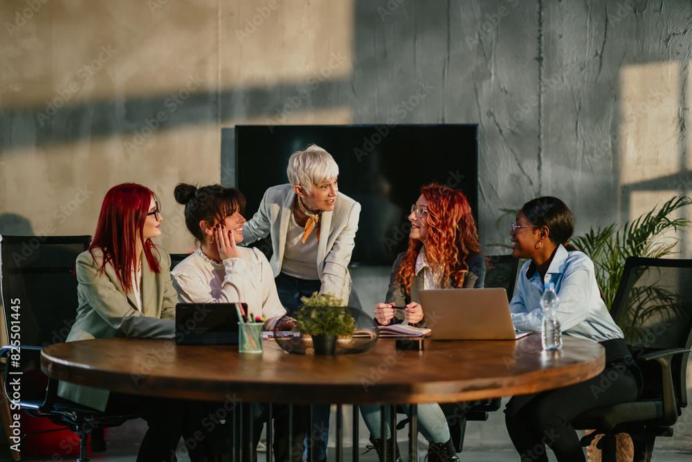 Senior female manager talking to her team at boardroom at corporation. Senior female manager talking to her team at boardroom at corporation.